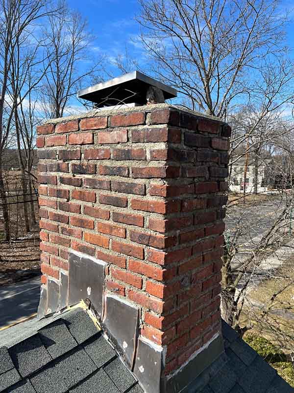 Before the restoration of a red brick chimney and a silver cap